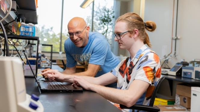 Student and professor use computer in lab